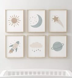 four framed pictures hang on the wall above a crib