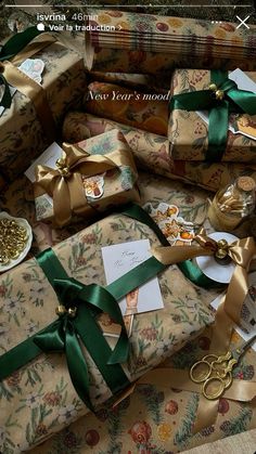 many wrapped presents with green ribbons and gold scissors are on the floor next to each other