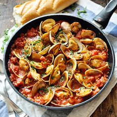 a skillet filled with pasta and clams