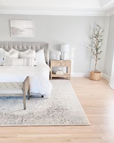 a bedroom with a large bed and white linens on the floor, along with two nightstands