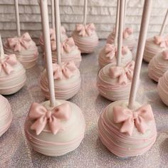 there are many pink cake pops with bows on them