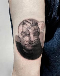 a man's arm with a black and white portrait on it