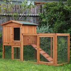 a wooden chicken coop in the grass