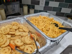 two trays filled with food sitting on top of a counter next to each other