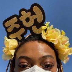 a woman wearing a face mask with flowers in her hair and the word go written on it