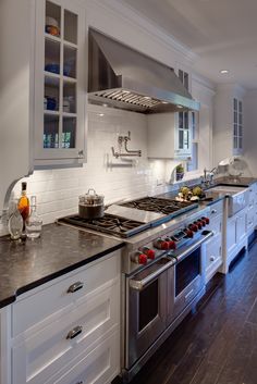 a kitchen with white cabinets and stainless steel appliances