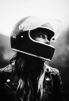 a woman wearing a motorcycle helmet and leather jacket