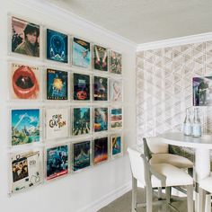 there is a white table and chairs in the room with many pictures on the wall