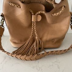 The Farrah Is An Icon In The Making. Her Classic Bucket Silhouette And Long, Drawstring Tassels Are A Nod To The Style Of Decades Past While Maintaining An Effortlessly Cool Vibe. Being Larger Version Of Our Original Nova, We Sometimes Call It The “Super-Nova” For Obvious Reason. The Meticulously Hand-Braided Leather Shoulder Strap And Drawstring Closure Truly Highlight The Craftsmanship Of The Piece. The Farrah Bucket Bag Can Be Worn Cinched Or Open, Accommodating Everything You Need For A Day Super Nova, Leather Pocket, Antique Brass Hardware, Aging Beautifully, Leather Bucket Bag, Leather Bucket, Stitching Leather, Braided Leather, Guatemala