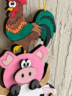 a wooden rooster and pig hanging on a wall