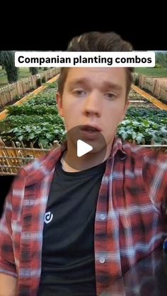 a man is making a funny face in front of some plants with words on it