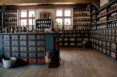 an old fashioned store with lots of bottles on the wall and shelves full of jars