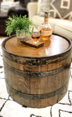 a wooden barrel coffee table sitting on top of a rug