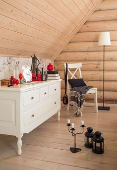 a room with wooden walls and flooring that has white furniture on top of it