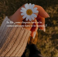 a person holding a daisy in their hand with the quote in life, some characters have to be turned and some have to be burned