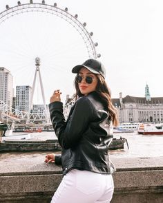 a woman standing in front of a ferris wheel