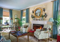 a living room filled with furniture and a fire place in front of a mirror on the wall