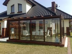 a house that is sitting in the grass with glass doors on it's side