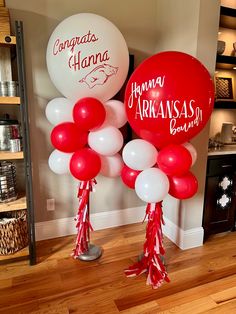 some balloons that are in the shape of two large red and white balloons with writing on them