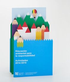 an image of a brochure with colored pencils on it's back