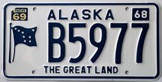 alaska license plate with the great land and an american flag on it's side