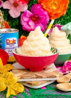 two bowls filled with ice cream sitting on top of a cutting board next to flowers