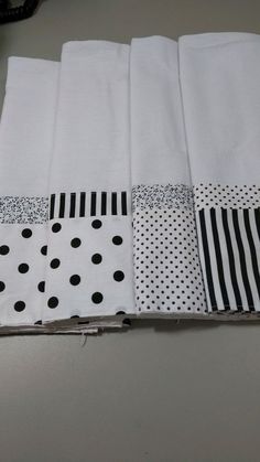 four pieces of white fabric with black and white polka dots on them are folded together