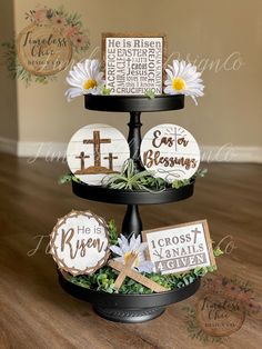 a three tiered cake with wooden signs and daisies