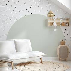 a white couch sitting on top of a rug in a living room next to a wooden shelf