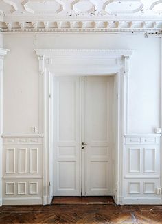 an empty room with white walls and wooden floors