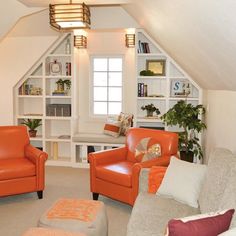 an attic living room with orange leather chairs and white shelving units in the corner