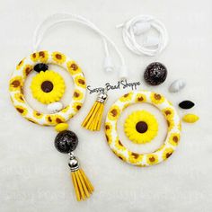 two pieces of jewelry with yellow flowers and black beads