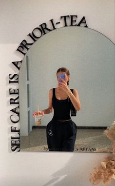 a woman taking a selfie in front of a mirror