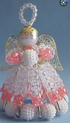 a beaded angel ornament with pink and white flowers on it's wings