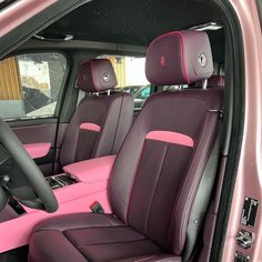 the interior of a pink and black car