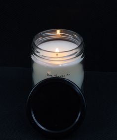 a white candle sitting on top of a black table