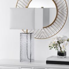 a white table with a mirror and flowers on it