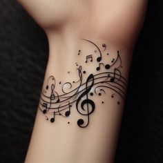 a wrist tattoo with musical notes on it's side and black dots around the band