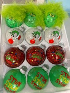 the grinch christmas ornaments are on display in a plastic box with green and red decorations