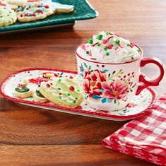 a cup and saucer on a table with cookies