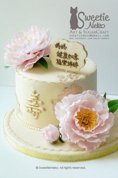 a white cake with pink flowers on top and chinese writing on the side that says sweetie nefeo