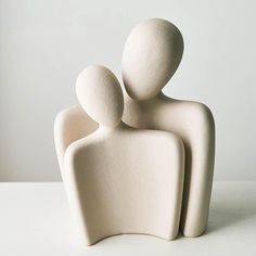 two white ceramic figurines sitting next to each other