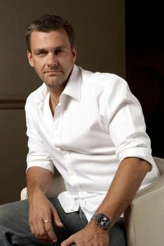 a man sitting in a chair wearing a white shirt