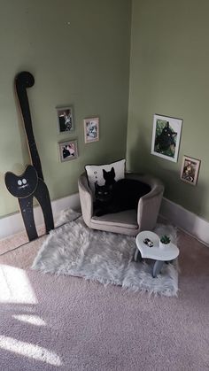 a cat sitting on top of a couch in a living room next to a guitar