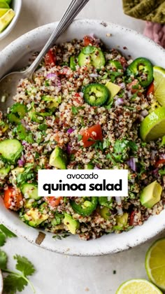 a bowl filled with rice, cucumber and other vegetables next to limes