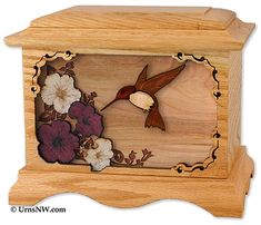 a wooden box with flowers and a hummingbird on it's side, in the shape of a flower