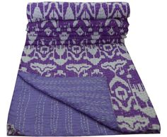 the purple and white blanket is folded on top of each other with an intricate pattern