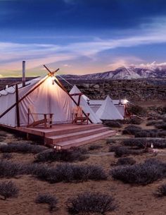 two tents in the desert with mountains in the background