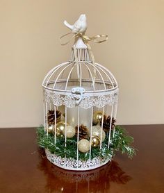 a white birdcage filled with ornaments on top of a table