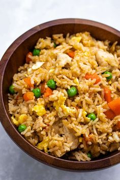 a wooden bowl filled with rice and vegetables